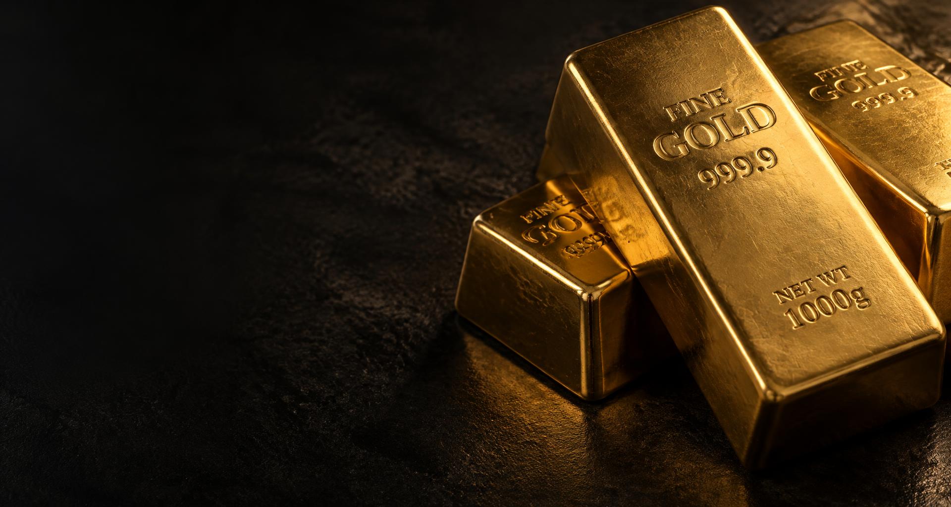 Fine gold bullion bars on dark stone